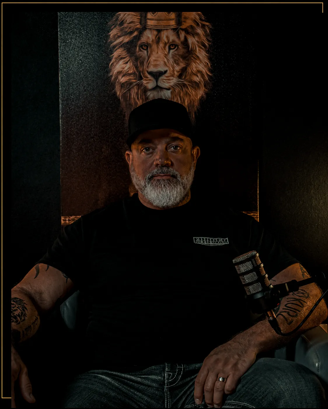David Adam Kurz seated at his podcast microphone in front of a crowned lion painting